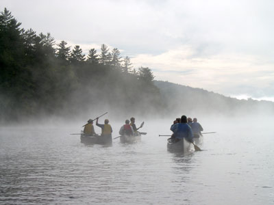 misty image of people canoeing on an Adirondack lake