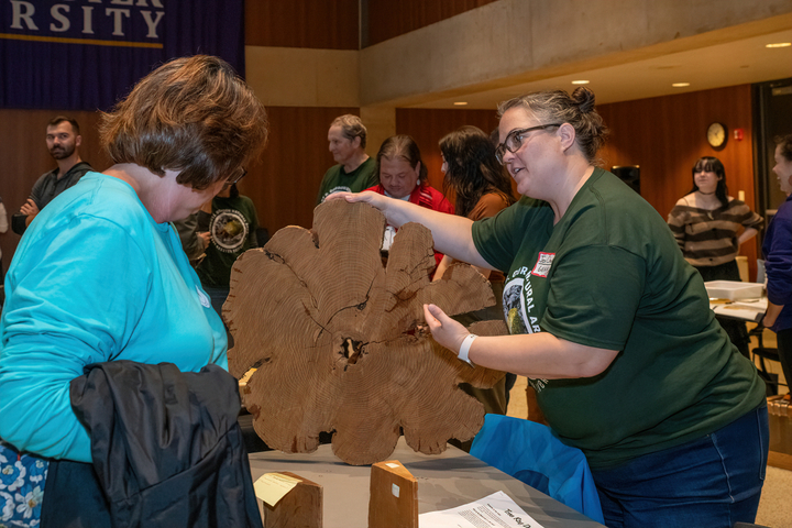 Dr. Jennifer Chandler (Department of Biology) discusses the finer points of tree rings with a Forest Festival participant