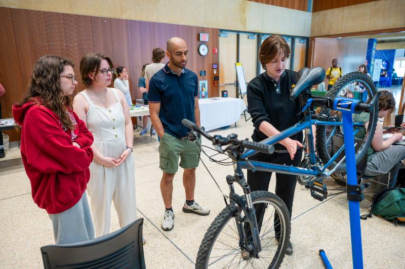 Three students look on as Kit Aiello talks through the ABCs of bicycle safety