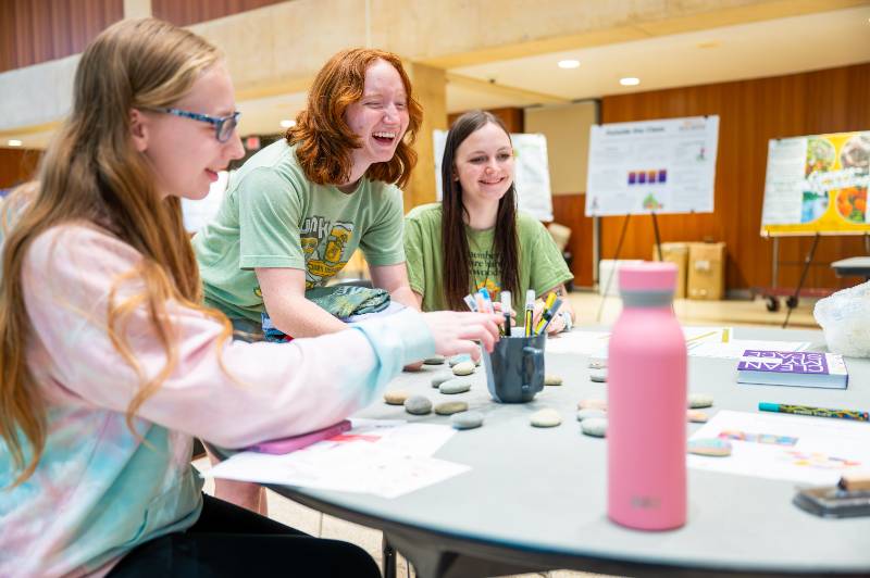 Students smile as they paint rocks at the Zero Waste Summit