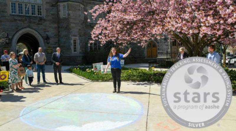 person standing on wcu campus by a flowering tree with a tour group
