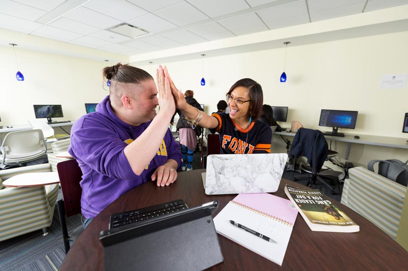 Student and teacher high fiving 