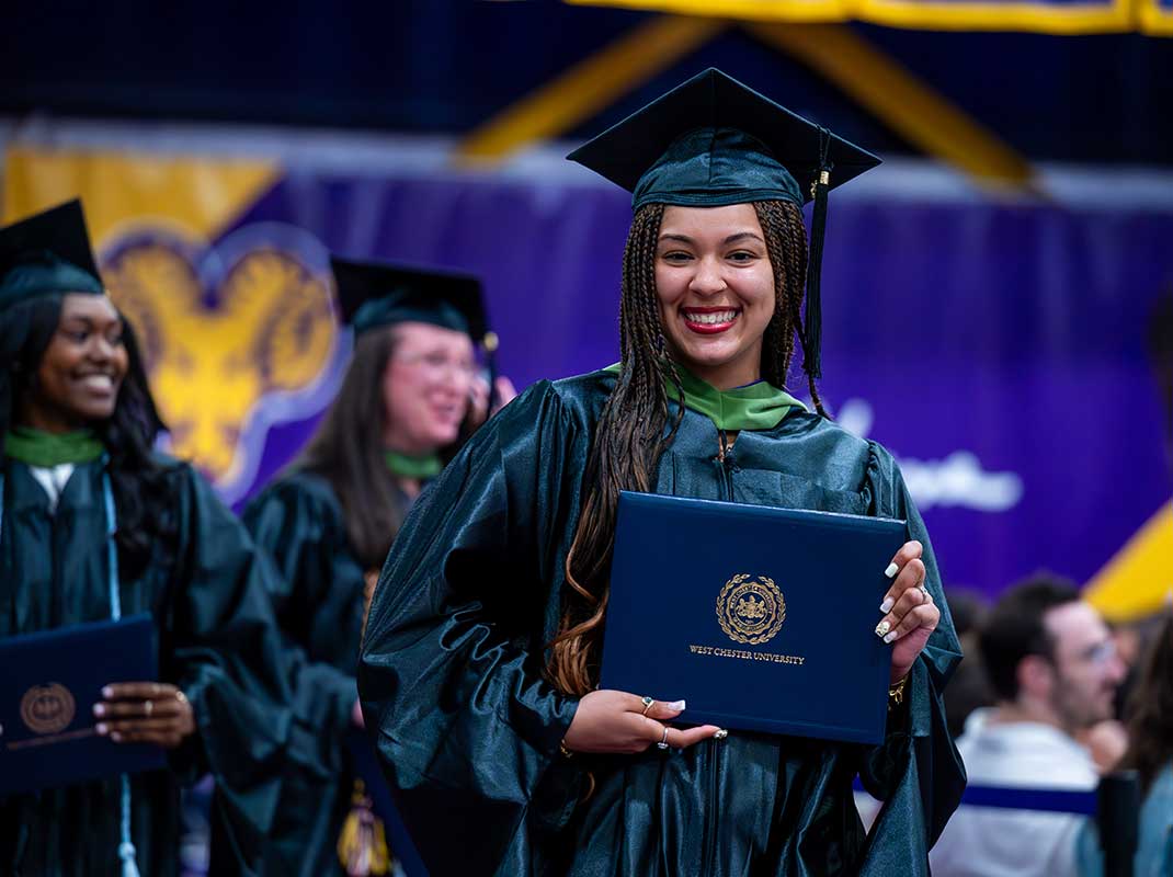 WCu student holding diploma at graduation