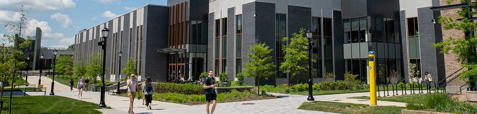 WCU Students walking in forn to f SECC building (on desktop devices) / Students cheering at a football game (on mobile phone devices)