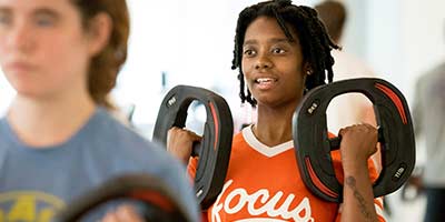 Female student holding weights