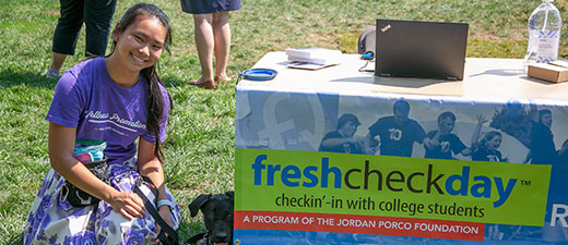 Programs thumbnail - a girl sits next to a table that says freshcheckday