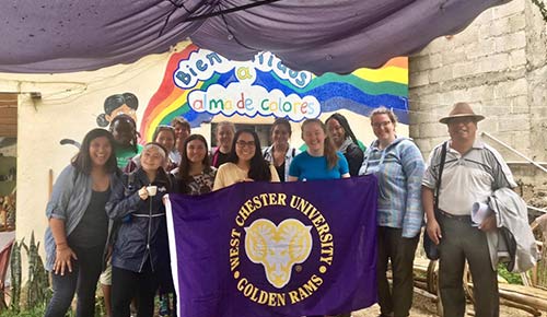 Students holding WCU flag in guatemala