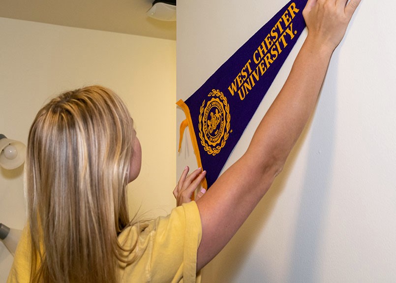 Student in dorm hanging WCU banner