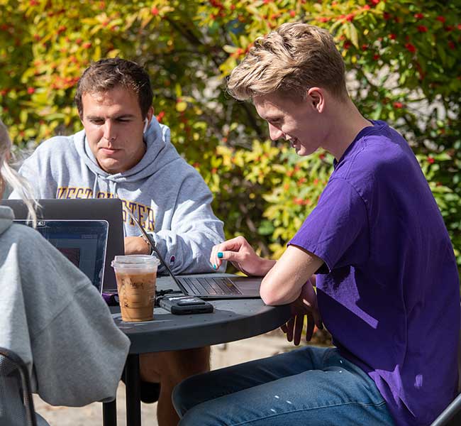 WCU Students sitting outside working on laptops