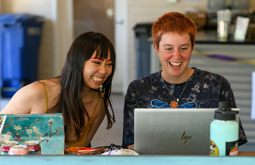 Two students on laptop laughing