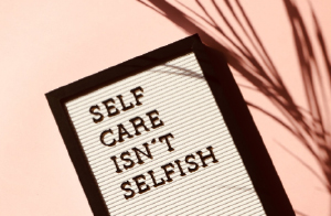 Image of sign with the words "Self Care Isn't Selfish"