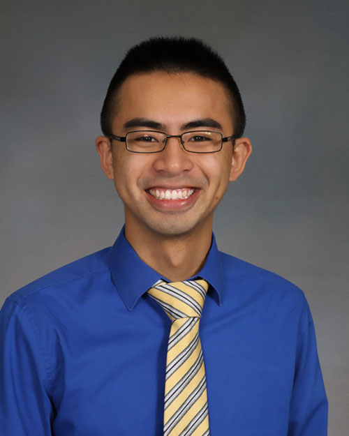 Student in blue dress shirt with a yellow tie
