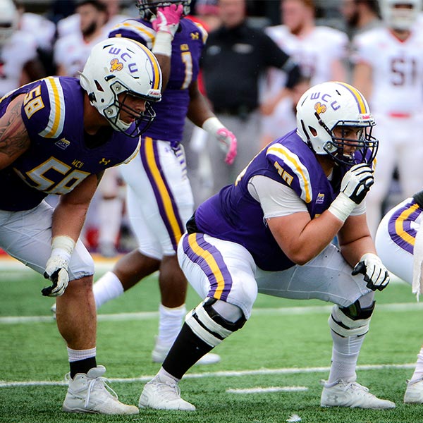 WCU football O line lining up to snap the football