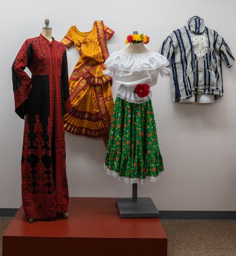 Intricate and inspiring fashion on display at Beyond the Bell: Philadelphia’s Global Heritage exhibition. Fashion heritage pictured (left to right) includes Palestinian thobe, South Indian Bharatanatyam dance costume, chapolera dress from Colombia, and a Liberian country cloth men’s tunic.