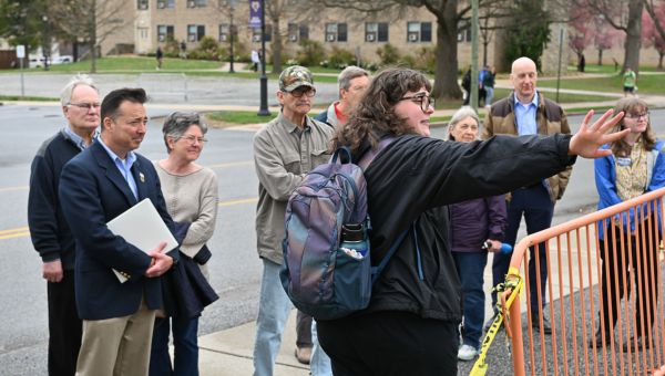 Calli Lambard (foreground), administrative assistant for WCU’s Office of Sustainability (OoS), took those who attended the PennEnvironment “Voices for Clean Energy” tour on April 3 to the University’s geoexchange pump house next to the OoS on West Rosedale Avenue. Among those who spoke at the event was PA State Representative Chris Pielli (blue blazer, khakis), who is serving as the University’s Legislative Fellow.