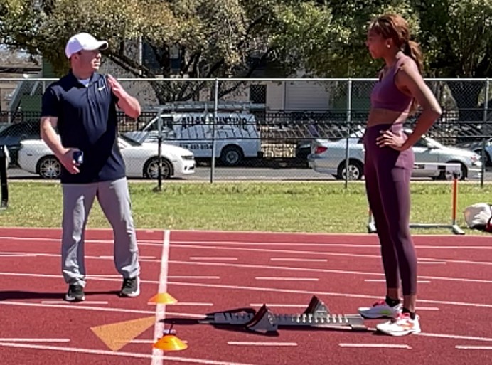 Gabby Thomas, a three-time Olympic gold medalist, consults with Dr. Ken Clark ’09, assistant professor of kinesiology