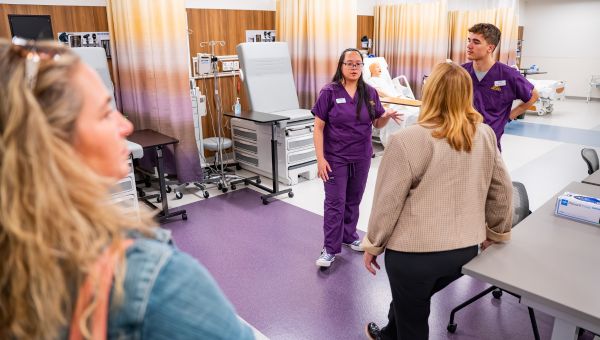 During the anniversary celebration of the nursing programs’ 50+ years, proud WCU nursing students gave tours of the state-of-the-art Immersive Learning Center that functions as a high-tech training ground with high-fidelity simulated manikins. (Pictured L to R) WCU nursing students, Christina Ngo and Adam Hudson, are pictured sharing details about the Center’s advanced capabilities with WCU alumnae.