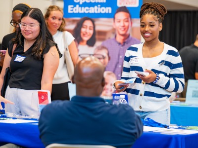 Two students talking to a future employer at the career fair