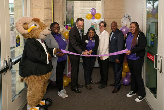 Rammy and staff members cutting a ribbon