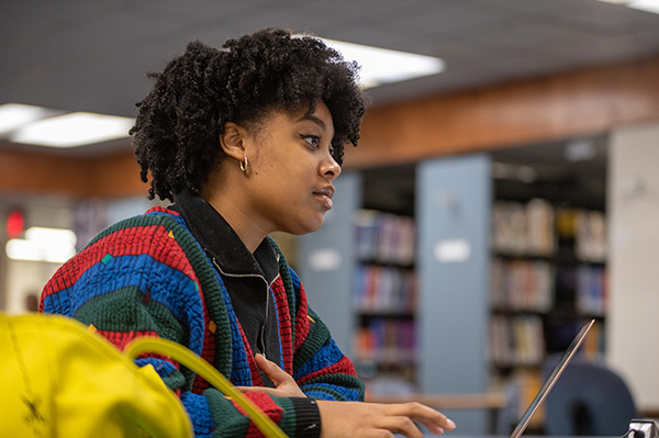 Female student working on laptop by herself