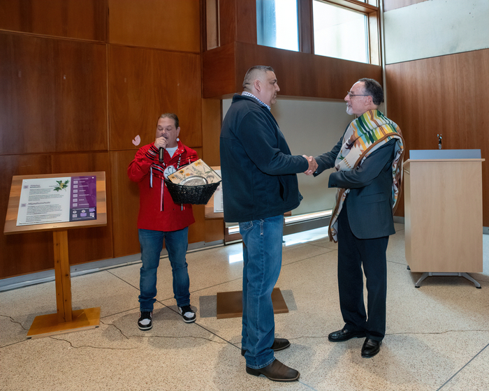 Representatives of the Delaware Tribe of Indians, Mr. Jeremy Johnson (left) and Chief KillsCrow (center) exchange gifts with WCU President Christopher Fiorentino