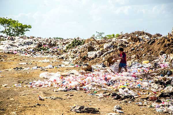 Person digging though trash dump