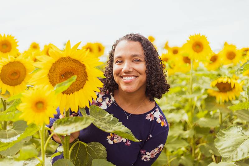 photo of alumna Aubrey Redd in a sunflower field
