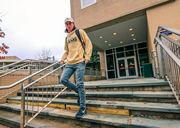 image of student walking down the steps outside of Schumucker