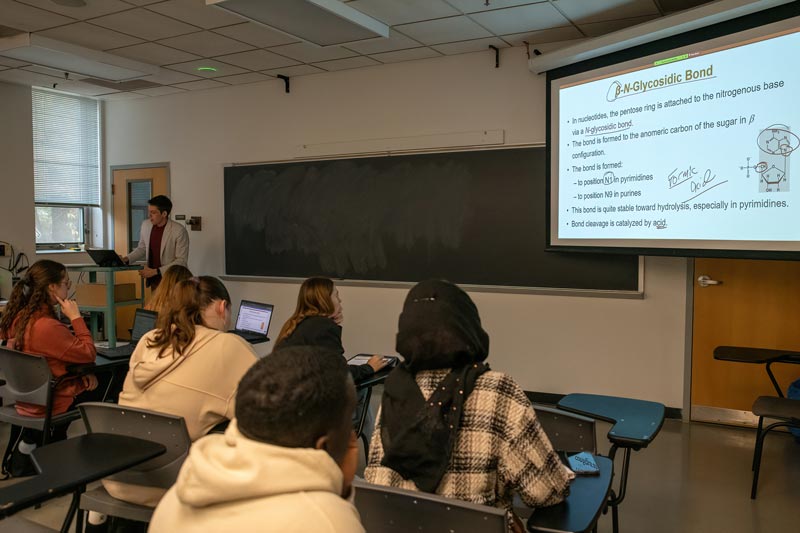 West Chester University of PA BioChemistry students in classroom with projector showing B-M-Glycosidic Bond