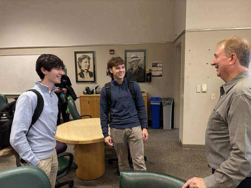 John Buchanan sharing a joke with two students.