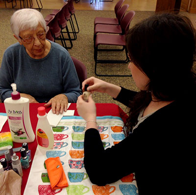 elderly woman receiving a manicure