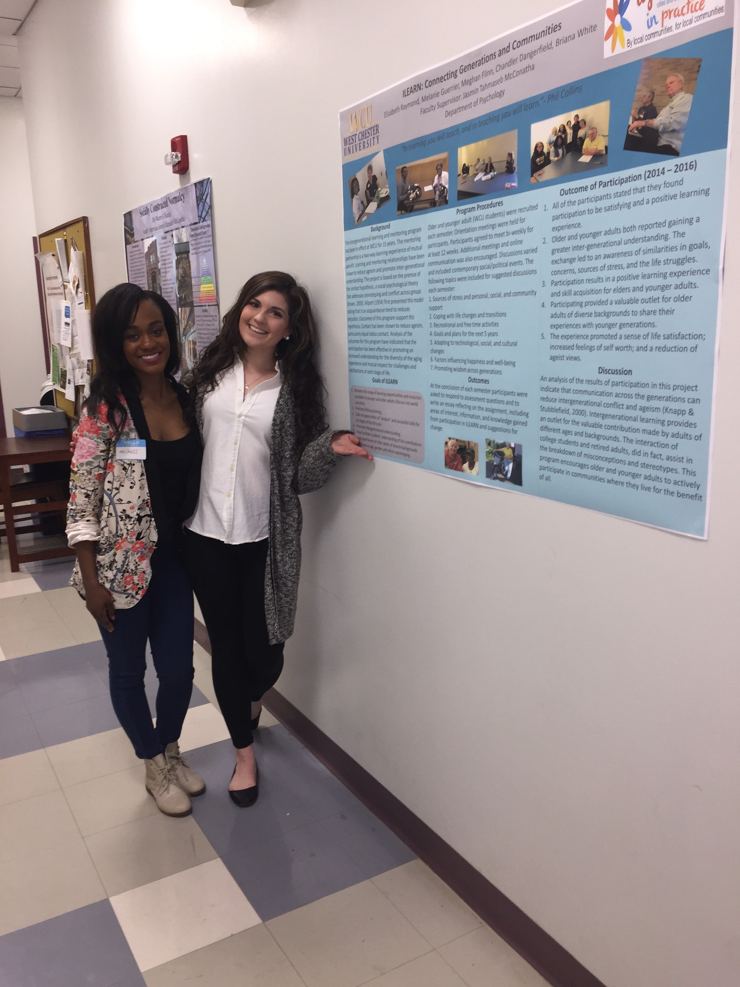 female students standing in front of poster