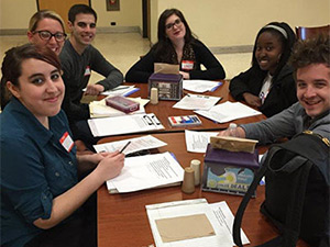 male and female students sitting around a table