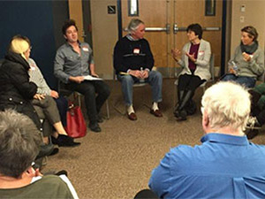 elderly people sitting in chairs in a circle