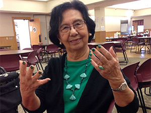 elderly woman showing holding up her hands showing her polished fingernails