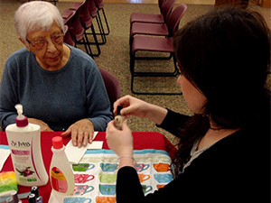 elderly woman receiving a manicure