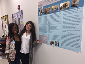 female students standing in front of poster