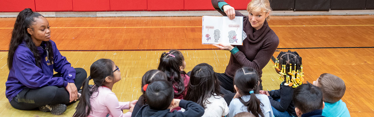 Woman reading to a group of children.