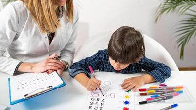 ADHD professional evaluating child via paper.