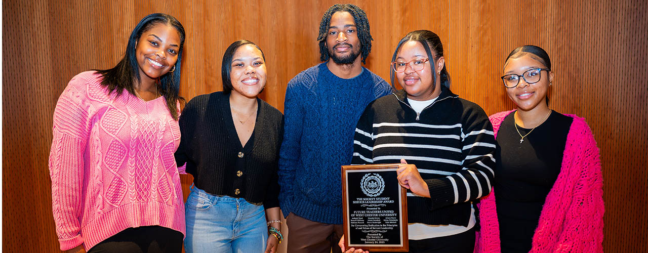 Group of award winners holding up a plaque