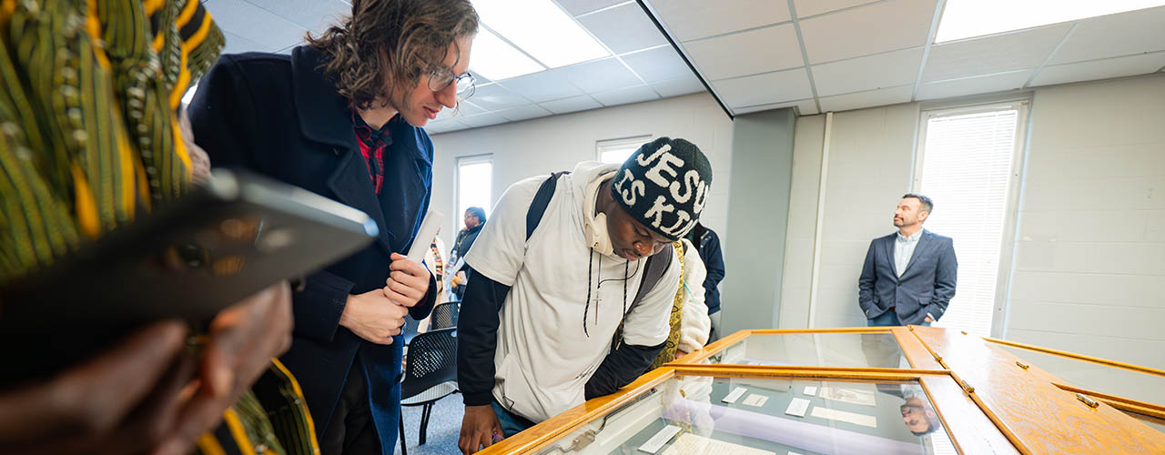 Participants looking at display cases with historical items