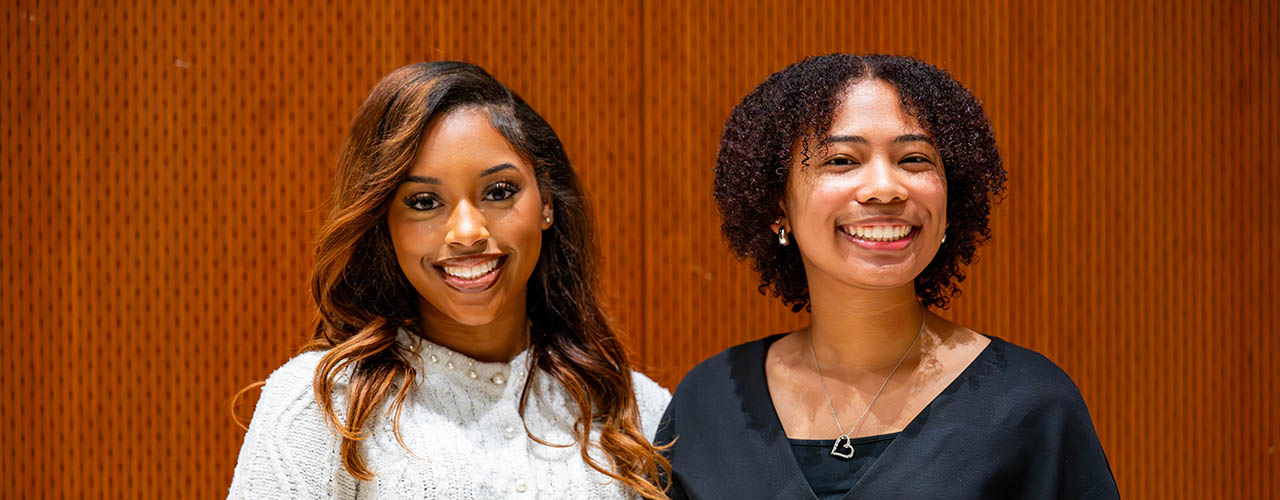 2 females posing for photo smiling