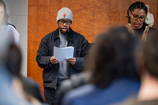 Candid photo from the Frederick Douglass day event. male student reading script.
