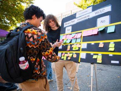 Two students discussing carpooling on campus for a research project